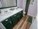 Charming bathroom with double sinks, wood-look floors, and a window for natural light, offers comfort and style at 9176 Lakeview Parkway, Villa Rica, GA 30180