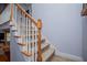 Carpeted staircase featuring white spindles, wooden handrail and trim that add a touch of elegance to the home's interior at 9176 Lakeview Parkway, Villa Rica, GA 30180