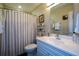 Bathroom with white vanity, shelves, decorative art, and gray and white striped shower curtain at 3259 Clairmont North Ne, Brookhaven, GA 30329