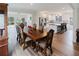 Elegant dining area with a large table, modern lighting, and open access to kitchen and living areas at 3991 Centennial Trl, Duluth, GA 30096