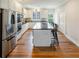 Bright kitchen boasts stainless appliances, white cabinetry, dark countertops and an island with seating at 3991 Centennial Trl, Duluth, GA 30096