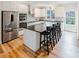 Bright kitchen boasts stainless appliances, white cabinetry, dark countertops and an island with seating at 3991 Centennial Trl, Duluth, GA 30096