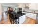 Bright kitchen boasts stainless appliances, white cabinetry, dark countertops and an island with seating at 3991 Centennial Trl, Duluth, GA 30096
