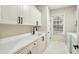 Well-lit laundry room with white cabinets, black hardware and a sink with a modern black faucet at 535 Telford Pl, Atlanta, GA 30342