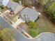 An aerial view of a home featuring a well-manicured lawn, mature trees, and a paved driveway at 251 Manous Way, Canton, GA 30115