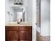 Bathroom featuring a single vanity with a wood cabinet, a large mirror, and a view of the shower at 251 Manous Way, Canton, GA 30115