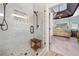View of a spacious bathroom shower with modern fixtures, marble walls, and a wooden seat at 251 Manous Way, Canton, GA 30115