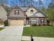Charming two-story brick and siding home with a manicured lawn and a two-car garage at 251 Manous Way, Canton, GA 30115