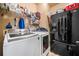 Functional laundry room with washer, dryer and black refrigerator at 251 Manous Way, Canton, GA 30115