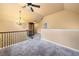 A finished loft area with neutral walls, carpet, and a decorative chandelier at 251 Manous Way, Canton, GA 30115