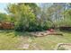 Spacious backyard with green grass, mature trees, a fire pit area, and an Adirondack chair at 3530 Embry Cir, Atlanta, GA 30341