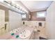 Neutral bathroom with pink countertop, white cabinets, shower/tub combination, and framed mirror with vanity lights at 3530 Embry Cir, Atlanta, GA 30341