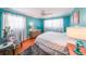 Vibrant bedroom with a plush rug, hardwood floors, and bright turquoise walls complemented by white curtains at 3530 Embry Cir, Atlanta, GA 30341