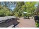 Outdoor deck area featuring a hot tub, table and chairs, and umbrella, all surrounded by trees and grass at 3530 Embry Cir, Atlanta, GA 30341