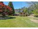 Expansive front yard of a brick home with mature trees and lush green lawn at 3530 Embry Cir, Atlanta, GA 30341