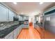 Stylish kitchen with gray cabinets, stainless appliances, stone counters, and hardwood floors at 3530 Embry Cir, Atlanta, GA 30341