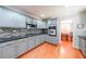 Updated kitchen boasts gray cabinets, hardwood floors, stainless steel appliances, and stone countertops at 3530 Embry Cir, Atlanta, GA 30341