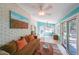 Cozy sunroom with tiled flooring, large windows, a white brick wall, a brown sofa, and comfortable seating at 3530 Embry Cir, Atlanta, GA 30341