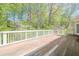 A spacious wooden back deck with wood railing overlooks lush trees at 370 Royal Birkdale Ct, Johns Creek, GA 30097