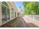A wooden back deck with wood railing along the back of the house overlooks lush trees at 370 Royal Birkdale Ct, Johns Creek, GA 30097