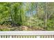 A lush green backyard view with mature trees and flowering bushes at 370 Royal Birkdale Ct, Johns Creek, GA 30097