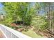 A lush green backyard view from the white deck with mature trees and flowering bushes at 370 Royal Birkdale Ct, Johns Creek, GA 30097