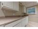 Basement kitchenette featuring a sink, cabinets, granite countertops, and a view from a window at 370 Royal Birkdale Ct, Johns Creek, GA 30097