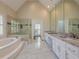Luxurious bathroom featuring a soaking tub, walk-in shower, dual sinks, and marble countertops at 370 Royal Birkdale Ct, Johns Creek, GA 30097