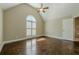 Bright bedroom with hardwood floors, vaulted ceilings, arched window, and ceiling fan at 370 Royal Birkdale Ct, Johns Creek, GA 30097
