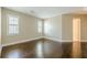 Bright bedroom featuring hardwood floors, neutral walls, and white-framed windows at 370 Royal Birkdale Ct, Johns Creek, GA 30097