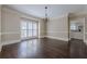 Formal dining room boasts hardwood floors, bright windows, chandelier, and an open doorway to the kitchen at 370 Royal Birkdale Ct, Johns Creek, GA 30097