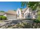 Front view of a stucco home featuring an attached garage, stone entryway and well-maintained lawn at 370 Royal Birkdale Ct, Johns Creek, GA 30097