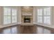 Living room fireplace with a stone surround and white mantel, flanked by shuttered windows at 370 Royal Birkdale Ct, Johns Creek, GA 30097