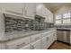 Modern kitchen featuring white cabinetry, stainless steel appliances, and a decorative backsplash at 370 Royal Birkdale Ct, Johns Creek, GA 30097