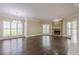 Elegant living room featuring a stone fireplace, large windows, and hardwood flooring at 370 Royal Birkdale Ct, Johns Creek, GA 30097
