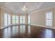 Bright and airy main bedroom featuring tray ceilings, hardwood floors, and plantation shutters at 370 Royal Birkdale Ct, Johns Creek, GA 30097