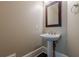 Elegant powder room with pedestal sink, modern faucet, and decorative mirror at 370 Royal Birkdale Ct, Johns Creek, GA 30097