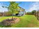 Expansive backyard with lush green grass, mature trees, and a covered patio perfect for outdoor entertaining at 4823 Layton Dr, Lithia Springs, GA 30122