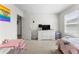 Charming bedroom featuring a pastel themed bedspread, a dresser with a tv, and ample natural light at 4823 Layton Dr, Lithia Springs, GA 30122