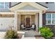 Charming covered porch with brick accents, seating, and a welcoming 'HOME' sign adds curb appeal at 4823 Layton Dr, Lithia Springs, GA 30122