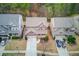 Aerial view of a two-story home nestled between two similar houses with well-maintained lawns and driveways at 5036 Maplecliff Dr, Sugar Hill, GA 30518