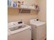 Modern laundry room with updated washer and dryer, open shelving and plenty of storage options at 5036 Maplecliff Dr, Sugar Hill, GA 30518