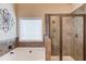 Bathroom featuring a soaking tub with tile surround and a glass enclosed shower at 5036 Maplecliff Dr, Sugar Hill, GA 30518