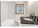 Bathroom with a tiled tub and shower, a dark granite countertop, and classic fixtures at 2695 Peeler Rd, Dunwoody, GA 30360