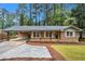 Charming brick home with a covered carport, landscaped front yard, and inviting front porch at 2695 Peeler Rd, Dunwoody, GA 30360