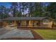 Charming brick home featuring a covered carport and a cozy front porch with stylish shutters at 2695 Peeler Rd, Dunwoody, GA 30360