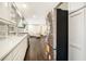 Modern kitchen with white cabinets, stainless steel appliances, and hardwood floors leading to a living area at 2695 Peeler Rd, Dunwoody, GA 30360