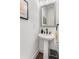 Modern half bathroom featuring a pedestal sink, framed mirror, and stylish fixtures in a compact space at 3980 Allegretto Cir, Atlanta, GA 30339