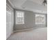 Large bedroom with neutral carpet, multiple windows, a ceiling fan, and a closet with double doors at 1754 Heights Nw Cir # 11, Kennesaw, GA 30152