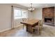 Bright dining room with a rustic wooden table, fireplace and large window at 5130 N Peachtree Rd, Dunwoody, GA 30338